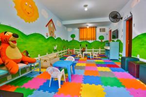 una sala de juegos infantil con un osito de peluche y un mural en Hotel Fazenda Village Montana, en Socorro