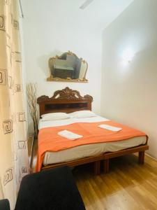 1 dormitorio con 1 cama con manta naranja y espejo en Roman Place, en Roma