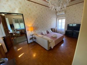 um quarto com uma cama, um espelho e uma televisão em VILLA FIESCHI em Cogorno