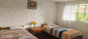 two beds in a room with a window and a table at Selva Mayo in Moyobamba +31 photos