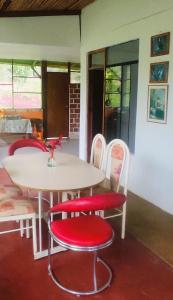 a table and chairs with a white table and red seats at Selva Mayo in Moyobamba
