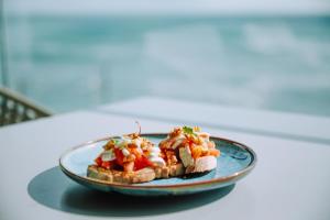 a plate of food with bread and vegetables on a table at InterContinental Cascais-Estoril by IHG in Estoril