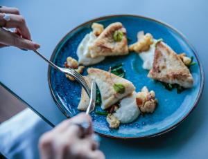 a person eating food on a blue plate at InterContinental Cascais-Estoril by IHG in Estoril