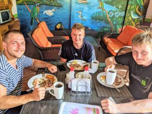 a group of three men sitting at a table eating food at Hospedaje Hefziba in Moyogalpa
