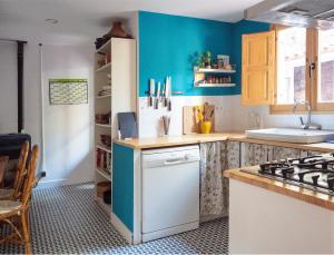 een keuken met blauwe muren en een fornuis met oven bij casa mediterrània a la vora de Barcelona in Corbera de Llobregat