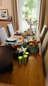 Les Hirondelles de la villa des roses في Pontmain: طاولة غرفة الطعام فوقها طعام