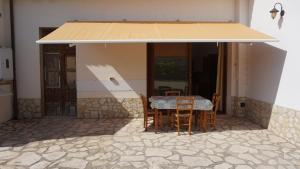 a house with a table and chairs under a roof at Country house relais Nonna Rosa Rosolini (SR) in Siracusa