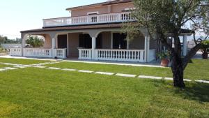 une grande maison avec un porche et une cour dans l'établissement Resort Amica, à Thurio