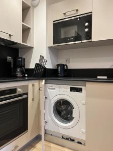 a kitchen with a washing machine and a microwave at CARLINA 105 in Morzine