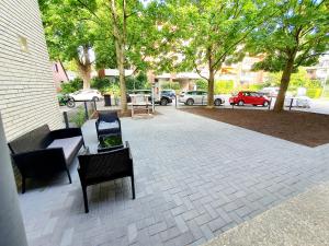 a patio with chairs and tables and trees at Pionier Hotel Hamburg Wandsbek 24H Self Check-in in Hamburg
