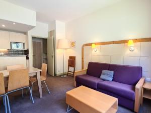 a living room with a purple couch and tables at Appartement Flaine, 2 pièces, 6 personnes - FR-1-425-153 in Flaine