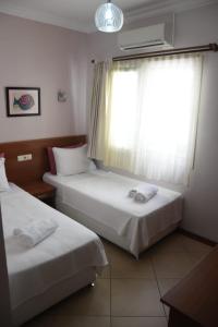 a hotel room with two beds and a window at Mia Butik Hotel Bodrum in Bodrum City