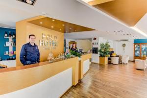 a man standing behind the counter of a hotel at BeYou Hotel Polo in Riccione