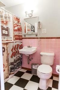 a pink bathroom with a toilet and a sink at Retro Inn at Mesa Verde in Cortez