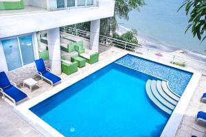 una piscina con sillas y un edificio en Hotel Santorini Casablanca en Santa Marta