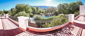 een looppad met hek en een zwembad bij La Candida departamentos in Merlo