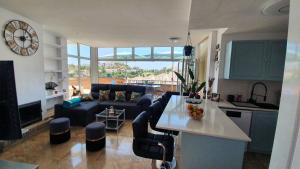 Una cocina y una sala de estar con un sofá y una mesa. en Green hills, en La Cala de Mijas
