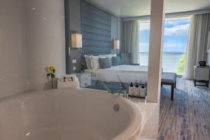 a bathroom with a tub and a bedroom with a bed at InterContinental Cascais-Estoril, an IHG Hotel in Estoril