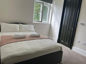 a bedroom with a bed with two pillows on it at Bright & Modern 2 bedroom In Hendon in Hendon
