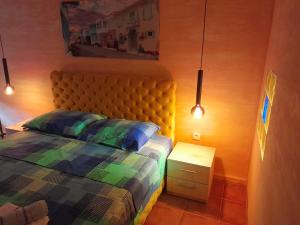 1 dormitorio con cama, mesita de noche y luces en Golden House Apartments en Čačak