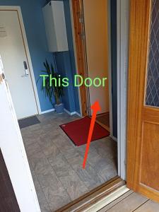 a door with a red arrow pointing into a room at FeelHome 4 bedrooms apartment Polarvegen in Tromsø