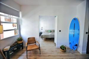 una sala de estar con una tabla de surf azul y una silla en La Candela en Santa Cruz de la Palma