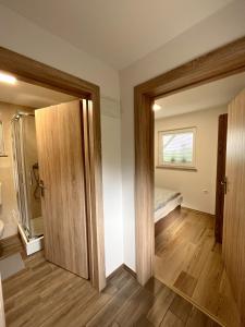 an empty room with a bed and a sliding door at Tomajna Vineyard Stay in Podlehnik