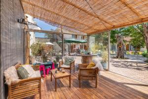 un patio al aire libre con sofá, sillas y mesa en Hotel Les Vieux Acacias, en Queyrac