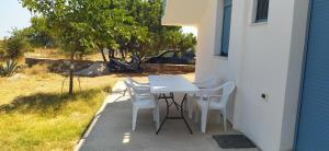 a white table and chairs sitting on a patio at Theros house in Kythira