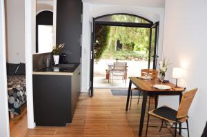 eine Küche und ein Esszimmer mit einem Tisch, einem Tisch und Stühlen in der Unterkunft Gîte proche des passerelles et du lac de Monteynard 