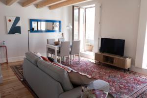 a living room with a couch and a table and a television at Casa Girasol River View in Porto
