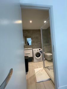 La salle de bains est pourvue d'un lave-linge et d'un lavabo. dans l'établissement appartement bas de villa avec piscine privée partagée proche bord de mer, à Cagnes-sur-Mer