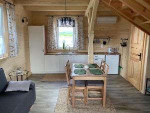 eine Küche und ein Wohnzimmer mit einem Tisch und Stühlen in der Unterkunft BURDANÓWKA in Skierbieszów