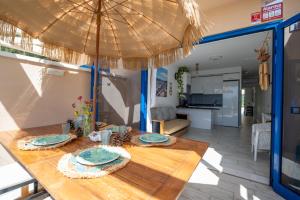 a dining table with an umbrella in a kitchen at Apartamentos Playa Feliz in Playa del Ingles