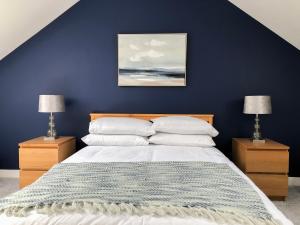 a blue bedroom with a bed with two night stands at Light & Spacious Loch Lomond Apartment in Alexandria