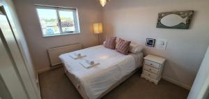 ein kleines Schlafzimmer mit einem Bett und einem Fenster in der Unterkunft Island Retreat in West Mersea