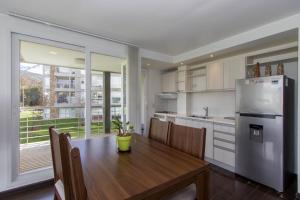 烏斯懷亞的住宿－Gray Fox Apartments Pipo，厨房配有木桌和冰箱。