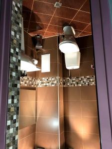 a shower with brown tile and a ceiling with lights at Radost in Varna City