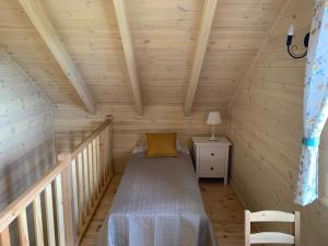 ein kleines Zimmer mit einem Bett in einer Holzhütte in der Unterkunft BURDANÓWKA in Skierbieszów