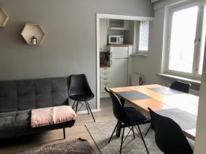 a living room with a couch and a table and chairs at Scandinavian apartments Heart of the city Kamppi 1, 5, 6 in Helsinki