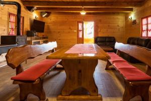 a wooden table and benches in a room at Kuća za odmor Lara in Otočac