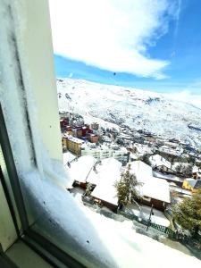 a view of a snow covered city from a window at Sky level Loft Sierra Nevada in Sierra Nevada