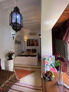 a bedroom with a bed and a chair and a chandelier at Dar Soukaina in Marrakech