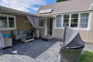 a house with a porch with a couch and a patio at Beach House with DSTV & WIFI & basic housekeeping in Knysna