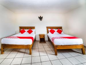 2 bedden in een kamer met rode en witte kussens bij Casa Banqueta Alta in Guanajuato