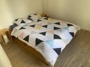 een slaapkamer met een zwart-witte quilt op een bed bij Chambres privées dans grand T4-Paris plein-centre in Parijs