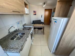 a small kitchen with a sink and a refrigerator at Gran College in Maringá