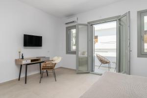 a bedroom with a desk with a computer and chairs at Olive Studios in Adamantas