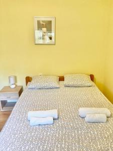 a bedroom with two beds with white sheets and pillows at Mlinovi in Zagreb