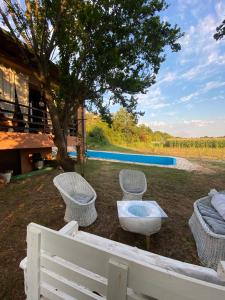 un patio trasero con mesa, sillas y piscina en Casa Madre Kravice Waterfalls, en Ljubuški